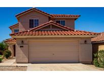 Two-story home with a two-car garage and red tile roof under a clear blue sky at 22322 W Loma Linda Cir, Buckeye, AZ 85326