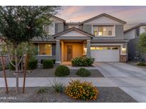 Charming two-story home featuring a landscaped yard and a welcoming front porch with beautiful flowerbeds at 23042 E Excelsior Ave, Queen Creek, AZ 85142
