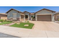 Charming home featuring desert landscaping, artificial turf, and a two-car garage at 26484 W Mohawk Ln, Buckeye, AZ 85396