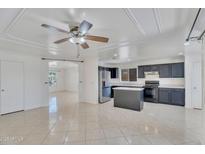 Bright kitchen features dark cabinetry, stainless steel appliances, and an island with stone countertops at 7551 W Pasadena Ave, Glendale, AZ 85303