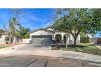 Charming single-story home featuring a welcoming front yard and gray two-car garage at 10402 E Javelina Ave, Mesa, AZ 85209