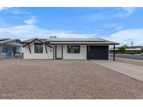 Charming single-story home with solar panels, a gravel yard, and a covered carport at 2002 W Windrose Dr, Phoenix, AZ 85029