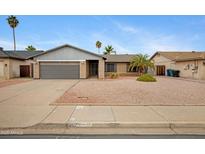 Charming brick home with desert landscaping and mature palm trees on a sunny day at 3106 S Extension Rd, Mesa, AZ 85210
