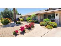 Charming home featuring a stone facade, walkway, and colorful desert landscaping in the front yard at 4617 E Emile Zola Ave, Phoenix, AZ 85032