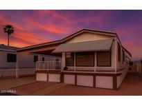 Charming single-story home featuring a covered porch and a beautifully colored sky at 7750 E Broadway Rd # 357, Mesa, AZ 85208