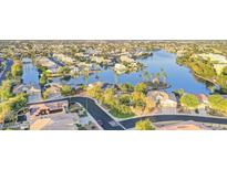 Aerial view of a neighborhood with lake, palm trees, and single Gathering homes at 8759 W Port Au Prince Ln, Peoria, AZ 85381