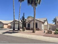Charming single-story home with well-maintained landscaping, mature palm trees, and a desert-friendly yard at 8759 W Port Au Prince Ln, Peoria, AZ 85381