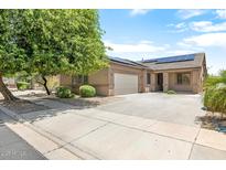 Single story home featuring solar panels, a two car garage, and desert landscaping at 12089 N 145Th Dr, Surprise, AZ 85379
