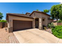 Charming single-Gathering home with a well-maintained front yard and a two-car garage on a sunny day at 14314 W Lexington Ave, Goodyear, AZ 85395
