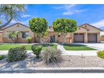 Charming home featuring manicured landscaping, vibrant green lawn, and a welcoming facade at 2652 N 143Rd Dr, Goodyear, AZ 85395