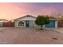 Charming single-story home with blue accents and a unique arched window, set against a desert landscape at 332 S 83Rd Pl, Mesa, AZ 85208
