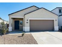 Inviting single-story home featuring a low-maintenance desert landscape, two car garage, and a covered entryway with a dark blue front door at 5019 E Umber Rd, San Tan Valley, AZ 85143
