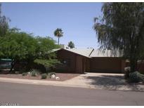 Charming single-story home features a two-car garage, desert landscaping, and mature shade trees at 8241 E Glenrosa Ave, Scottsdale, AZ 85251