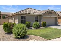 Charming single-story home featuring a neutral color palette, well-manicured lawn, and tidy landscaping at 9329 E Olla Ave, Mesa, AZ 85212