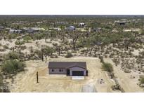 An aerial view shows this single-Gathering home surrounded by desert vegetation and other structures at 10772 N Biznaga St, Florence, AZ 85132