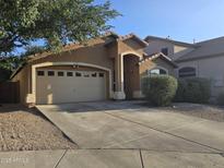 Charming single-story home featuring a two-car garage, desert landscaping, and a welcoming front porch at 1309 E Julie Ct, San Tan Valley, AZ 85140