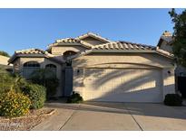 Charming single-story home featuring a two-car garage, desert landscaping, and tile roofing at 1417 E Century Ave, Gilbert, AZ 85296