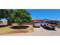 Charming single-story home with a well-maintained lawn and mature tree, exuding curb appeal at 1438 W 7Th St, Tempe, AZ 85281
