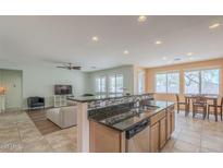 Bright open kitchen area with granite countertops, a breakfast bar, and stainless steel appliances at 16526 W Calle Lejos --, Surprise, AZ 85387