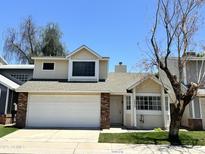 Charming two-story home featuring a white garage door and a well-maintained front lawn at 18629 N 4Th Dr, Phoenix, AZ 85027