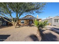 Charming brick home with mature tree and low-maintenance desert landscaping in the front yard at 1950 W Palm Ln, Phoenix, AZ 85009