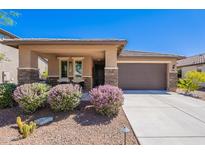 Charming single-story home with desert landscaping, covered porch, and two-car garage at 20641 W College Dr, Buckeye, AZ 85396