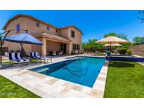 Inviting backyard featuring a pool, covered patio seating and a grassy yard at 3760 W Lapenna Dr, New River, AZ 85087