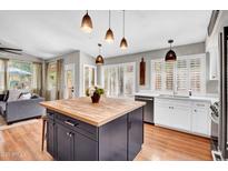 Bright kitchen features a butcher block island, modern white cabinetry, and beautiful pendant lighting at 4350 E Gatewood Dr, Phoenix, AZ 85050