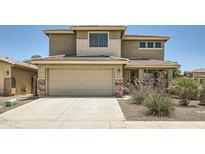 Inviting two-story home featuring a two-car garage and desert landscaping in the front yard at 45311 W Woody Rd, Maricopa, AZ 85139