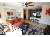 Bright living room featuring a ceiling fan, comfortable seating, and a view of the kitchen at 5345 E Van Buren St # 115, Phoenix, AZ 85008