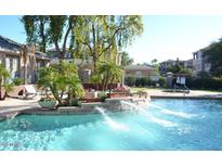 Community pool with waterfalls, lush landscaping and lounge chairs at 5345 E Van Buren St # 116, Phoenix, AZ 85008
