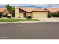 Charming single-story home with a well-manicured lawn and tile roof at 7420 W Morrow Dr, Glendale, AZ 85308