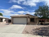 Charming home featuring a tile roof, two-car garage, and low maintenance front yard landscaping at 8738 W Griswold Rd, Peoria, AZ 85345