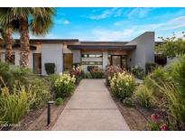 Contemporary home showcasing a beautifully landscaped front yard with vibrant plants and a quaint walkway at 9148 N 66Th Pl, Paradise Valley, AZ 85253