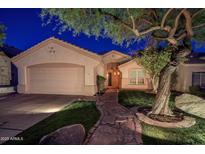 Charming single-story home featuring a stone walkway, two car garage, and mature landscaping at 10141 E Floriade Dr, Scottsdale, AZ 85260