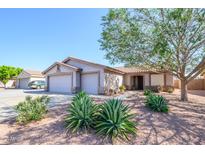 Charming single-story home featuring desert landscaping, a spacious three-car garage, and a well-maintained front yard at 14938 W Mauna Loa Ln, Surprise, AZ 85379