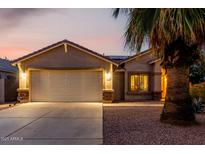 Charming single-story home featuring a well-maintained front yard, an attached two-car garage and desert landscaping at 16526 W Desert Ln, Surprise, AZ 85388