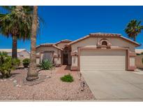 Charming single-story home featuring a two-car garage and mature landscaping at 17585 N Coyote Lakes Pkwy, Surprise, AZ 85378