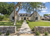Elegant home exterior featuring lush green lawn, mature shade trees, and a welcoming walkway leading to the entrance at 325 W Solano Dr, Phoenix, AZ 85013