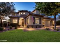 Elegant home featuring beautiful stone accents, arched entryway, landscaped yard, and an American flag at 5434 E Barwick Dr, Cave Creek, AZ 85331