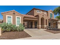 Charming two-story home featuring a terracotta tile roof, arched entry, and low-maintenance desert landscaping at 5707 N Kristi Ln, Litchfield Park, AZ 85340