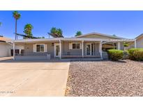 Charming single-story home featuring desert landscaping, covered porch, and shade awnings at 619 S Essex Ln, Mesa, AZ 85208