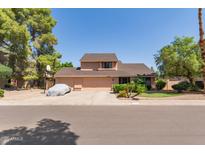 Charming two-story home with a large front yard, covered car, and mature trees at 6446 E Beverly Ln, Scottsdale, AZ 85254