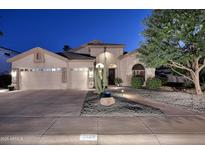 Charming home showcasing a three-car garage, desert landscaping, and inviting front entrance at twilight at 1085 E Oakland Ct, Gilbert, AZ 85295