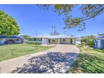 Charming single-story home with a covered carport and a lush green lawn in a desirable neighborhood at 1917 W Ashland Ave, Phoenix, AZ 85009