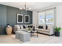 Stylish living room featuring a plush gray sectional, modern lighting, and elegant decor at 24079 W Cocopah St, Buckeye, AZ 85326