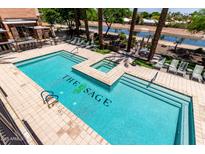Relaxing pool area with lounge chairs, palm trees, and the community name at The Sage at 4803 N Woodmere Fairway -- # 1002, Scottsdale, AZ 85251