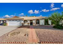 Charming single-story home featuring a well-maintained facade, desert landscaping, and an arched front door at 5803 W John Cabot Rd, Glendale, AZ 85308