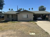 A cozy single-story home with a carport, desert landscaping, and a charming, sun-drenched facade at 61 W 11Th Dr, Mesa, AZ 85210