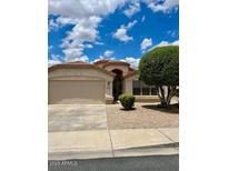 Single-story home featuring a large front yard, a two-car garage and a well maintained desert landscape at 6376 W Adobe Dr, Glendale, AZ 85308